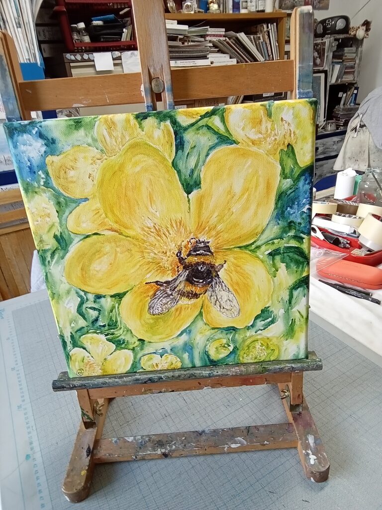 a painting of a great yellow bumblebee on  yellow flower on an easel. 