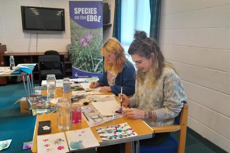 Two people painting with watercolour